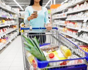 Kundin mit einem gefüllten Einkaufswagen im Supermarkt