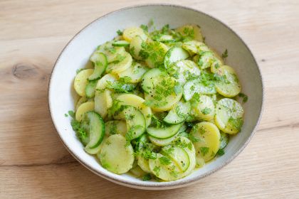 Kartoffel-Gurkensalat mit Pimpinelle in einer hellen Schüssel