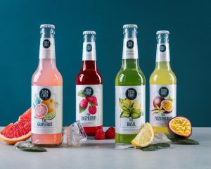 Die vier Soda Libre Sorten mit Früchten und Eis vor türkisfarbenem Hintergrund
