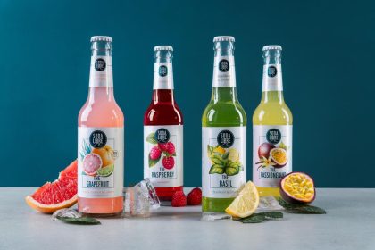 Die vier Soda Libre Sorten mit Früchten und Eis vor türkisfarbenem Hintergrund
