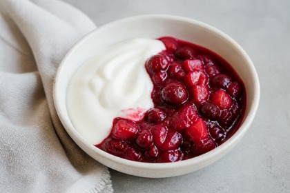 Rotes Cranberry-Preiselbeer-Kompott mit Birnenwürfeln und Naturjoghurt