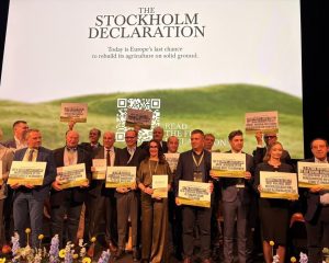 Vertreter europäischer Bauern- und Genossenschaftsverbände mit Schildern vor der Präsentation der Stockholmer Erklärung.
