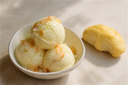 Cremiges Durian-Kokos-Eis mit Kokoschips und Limettenzesten