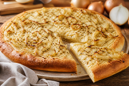 Goldbraun gebackener Zwiebelkuchen mit Federweißer im Guss