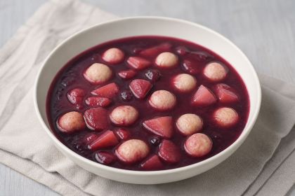 Dunkle Holunderbeeren-Suppe mit Apfelstücken und Grießklößchen