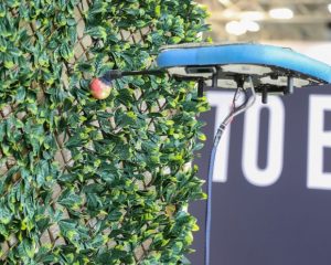 Eine Drohne pflückt einen Apfel und symbolisiert den Fortschritt in Smart Agriculture, Farming Forward und Vertical Farming.