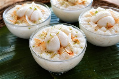 Cremiger Kokos-Milchreis mit weißem Mangostanen-Fruchtfleisch, Kokoschips und Limettenabrieb