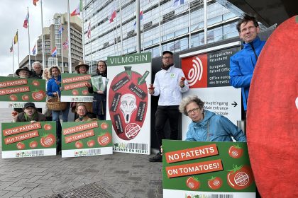 Gruppe mit Protestschildern gegen Tomatenpatente vor dem Europäischen Patentamt in Den Haag.