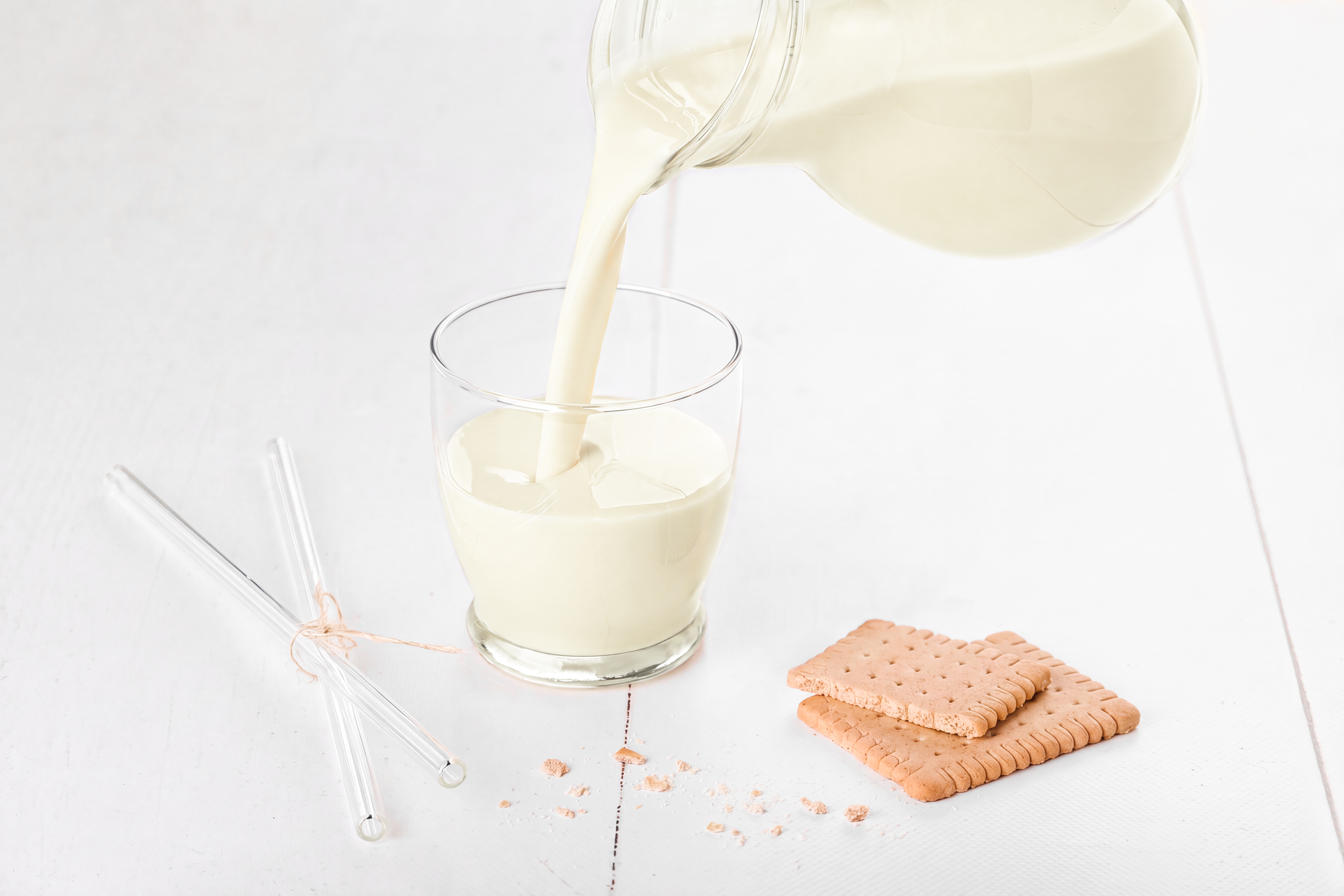 Pflanzliches Getränk mit Mandel-Zimt-Aroma neben Mandeln und Gebäck