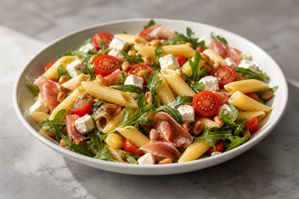 Penne mit Rucola, Feta, Schinken, Tomaten und Pinienkernen
