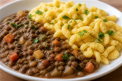 Vegetarische braune Linsen mit Möhren und Sellerie, serviert mit Spätzle