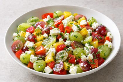 Herzhafter Salat aus roten und grünen Tafeltrauben, bunter Paprika, Schafskäse und Petersilie