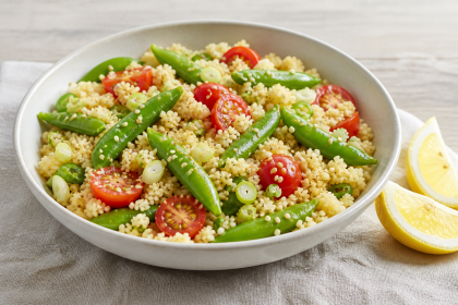 Couscous mit gegarten Zuckerschoten, Kirschtomaten, Frühlingszwiebeln und Sesam